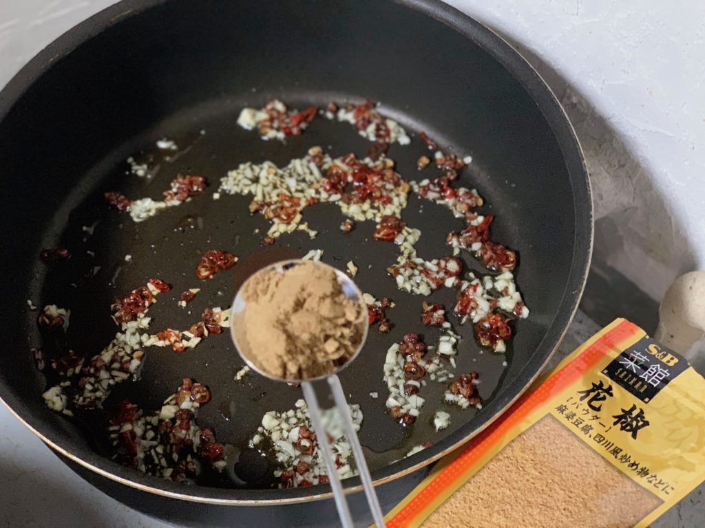 ⑩ フライパンの火を止めてから、花椒（粉末）を追加して軽く混ぜ合わせる